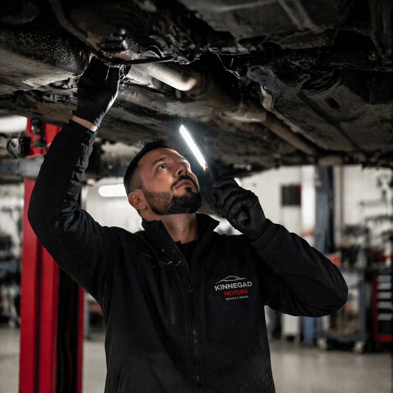 Mechanic inspecting a car on the ramp at Kinnegad MOTORS workshop